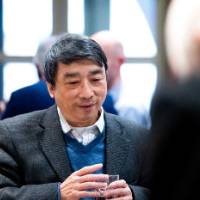 Man holds drink and smiles